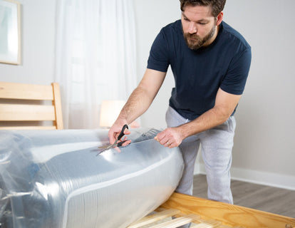 Man cutting open his new BedInABox® Mattress