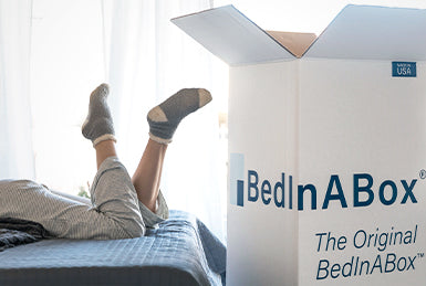 bed in a box next to person on bed